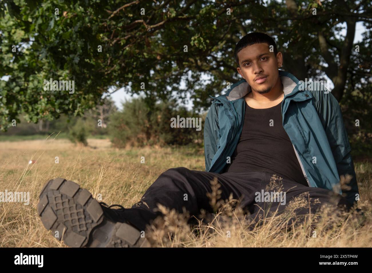 Porträt eines Mannes, der auf Gras sitzt Stockfoto