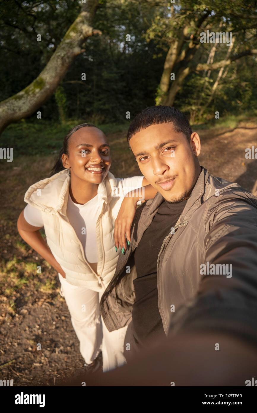 Porträt eines lächelnden Paares, das Selfie im Wald macht Stockfoto