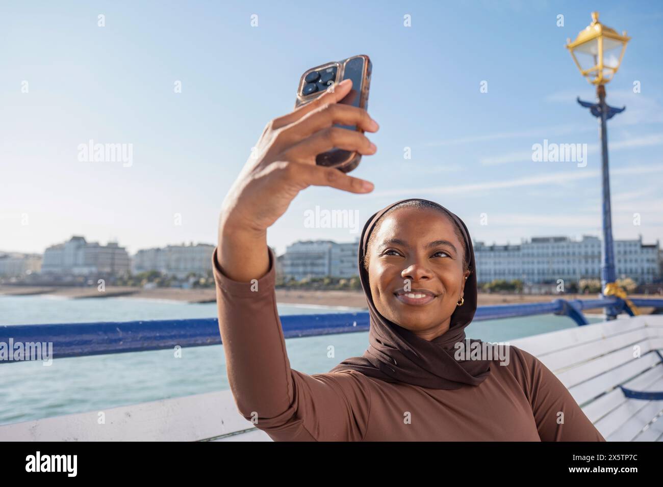 Muslimische Frau macht Selfie mit Meerblick an sonnigen Tagen Stockfoto