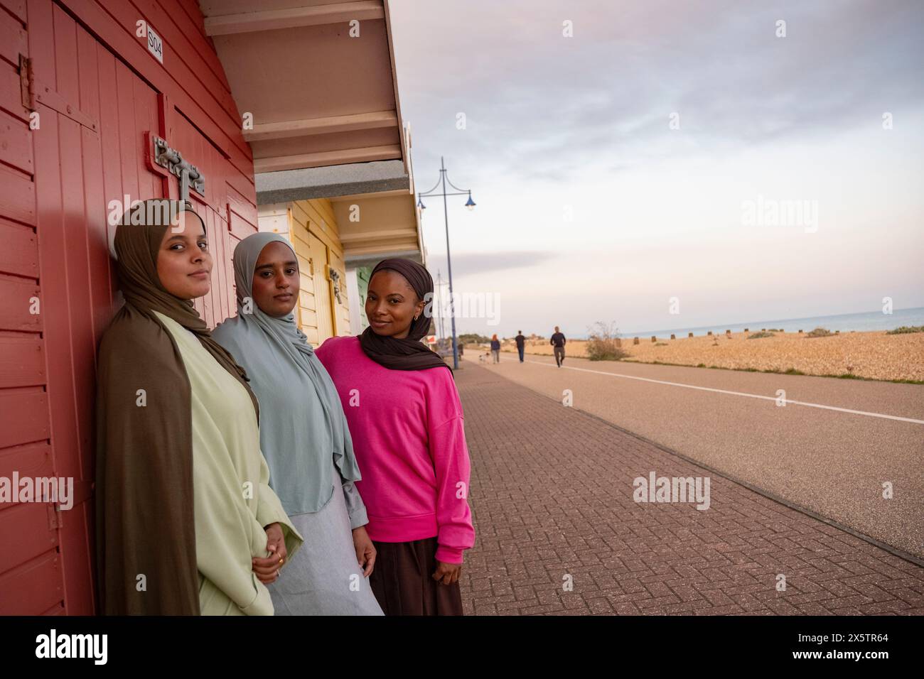 Porträt von drei muslimischen Freunden, die vor der roten Strandhütte stehen Stockfoto