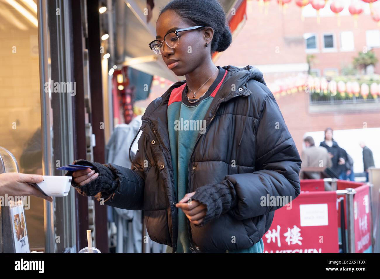 Eine junge Frau, die im Straßenrestaurant in Chinatown Essen bestellt Stockfoto