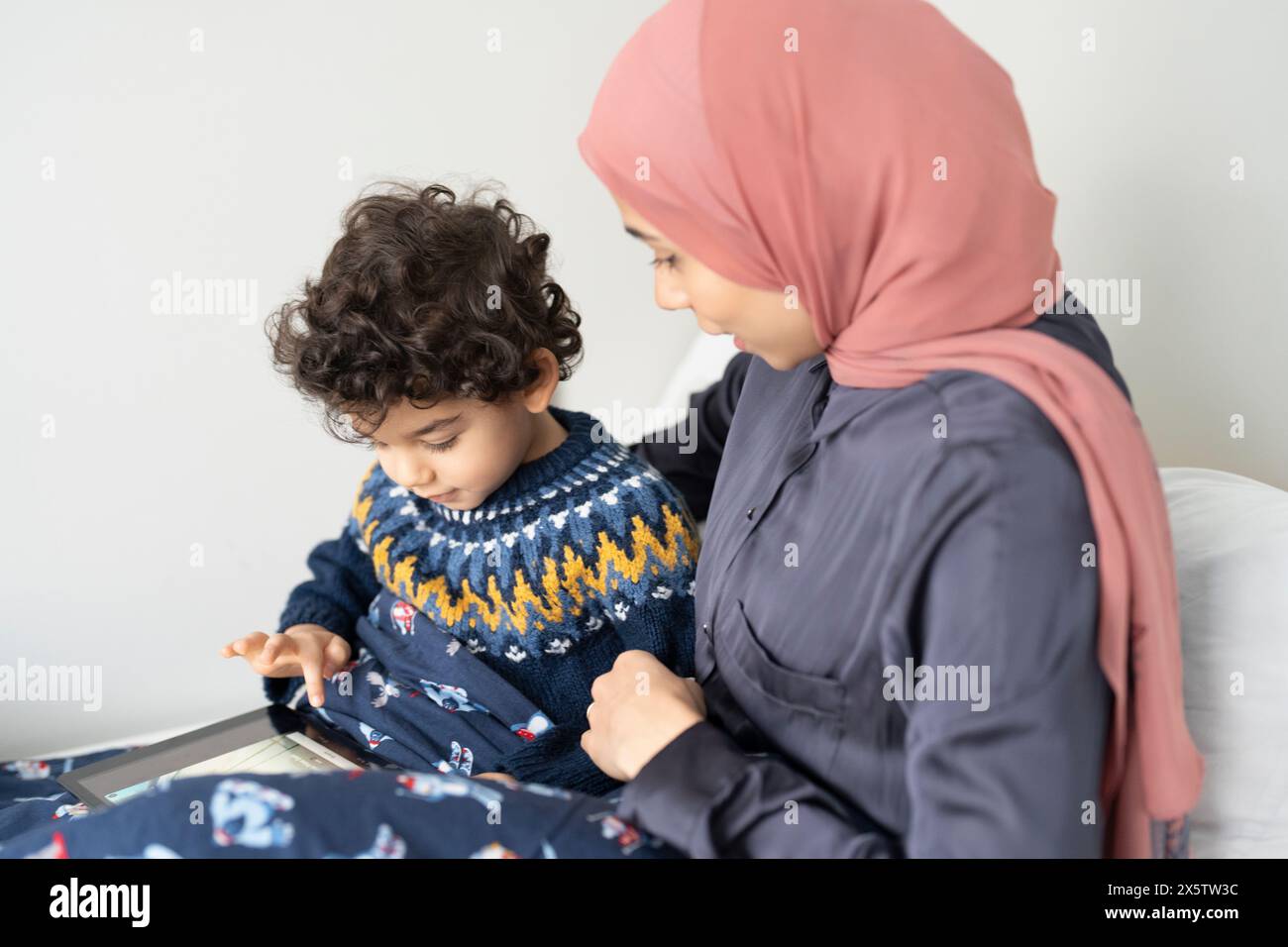 Mutter und Sohn (2-3) mit digitalem Tablet im Bett Stockfoto