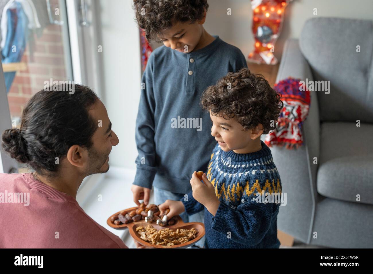 Vater und Söhne (2-3, 6-7) teilen sich Nahrung Stockfoto