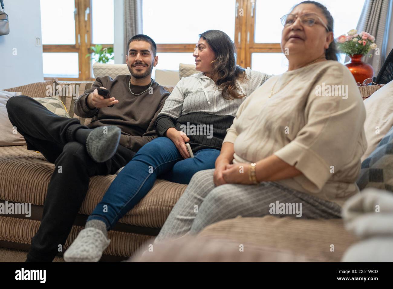 Lächelnde 3-Generationen-Familie, die fernsieht Stockfoto