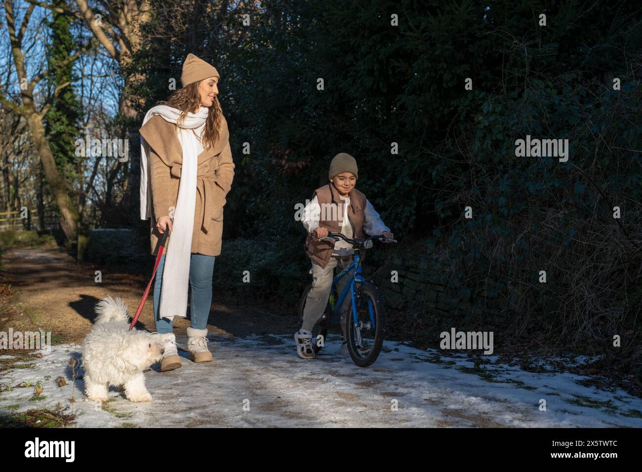 Mutter und Sohn (6-7) machen einen Spaziergang am Winternachmittag Stockfoto