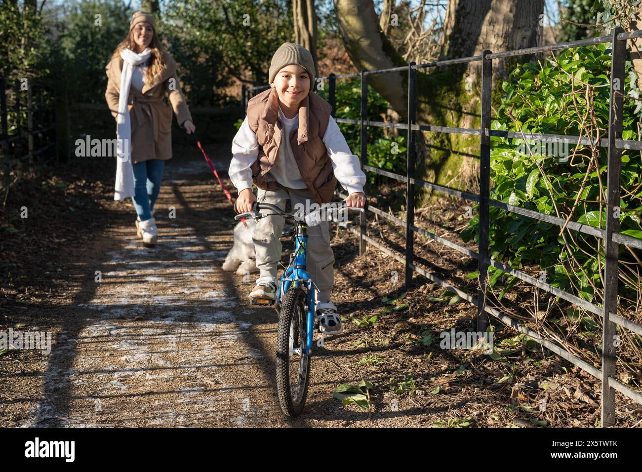 Mutter und Sohn (6-7) machen einen Spaziergang am Winternachmittag Stockfoto