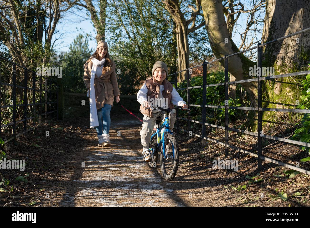 Mutter und Sohn (6-7) machen einen Spaziergang am Winternachmittag Stockfoto