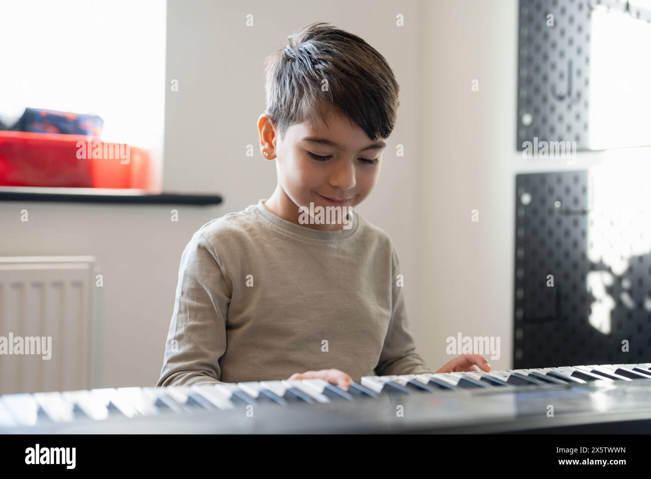 Junge (6–7) spielt zu Hause Musik-Keyboard Stockfoto