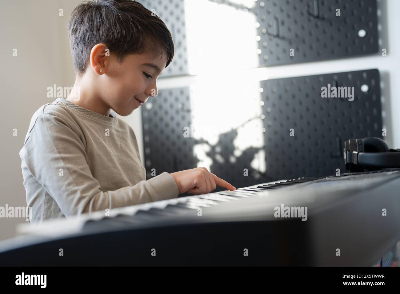 Junge (6–7) spielt zu Hause Musik-Keyboard Stockfoto