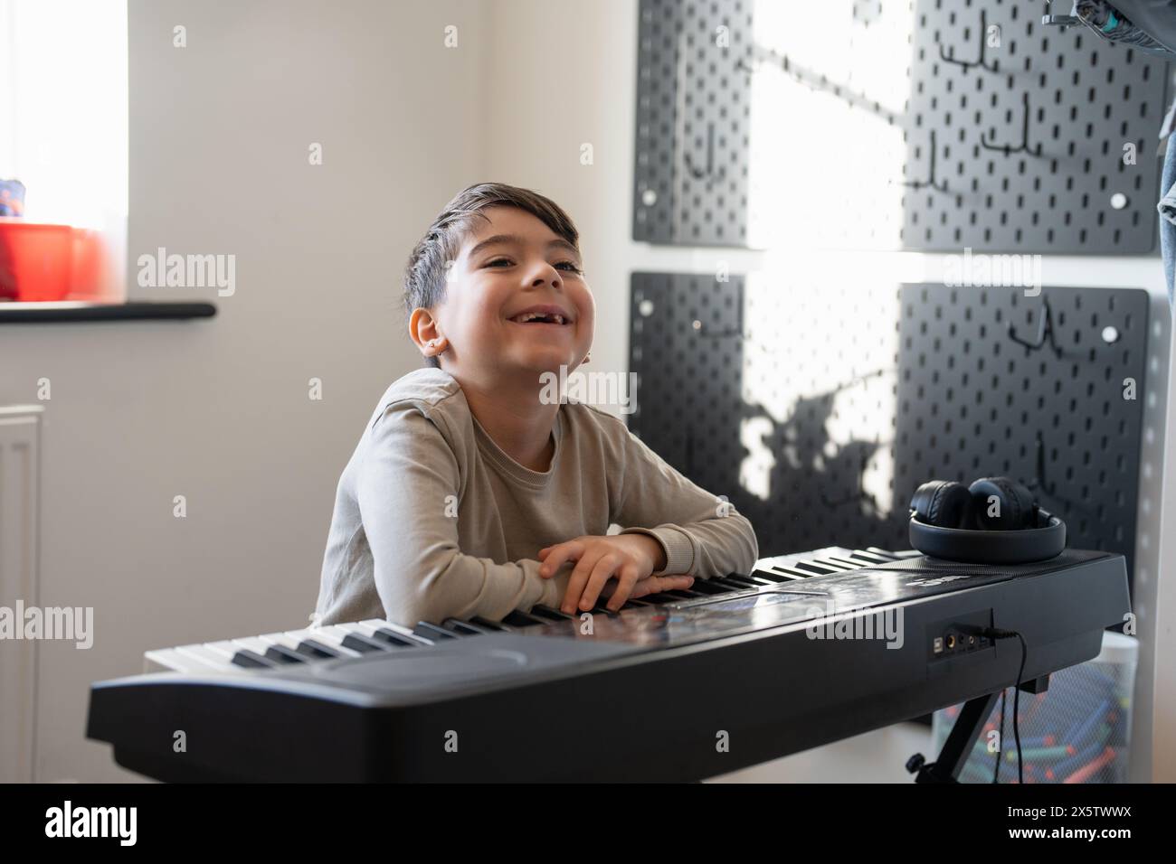 Junge (6–7) spielt zu Hause Musik-Keyboard Stockfoto