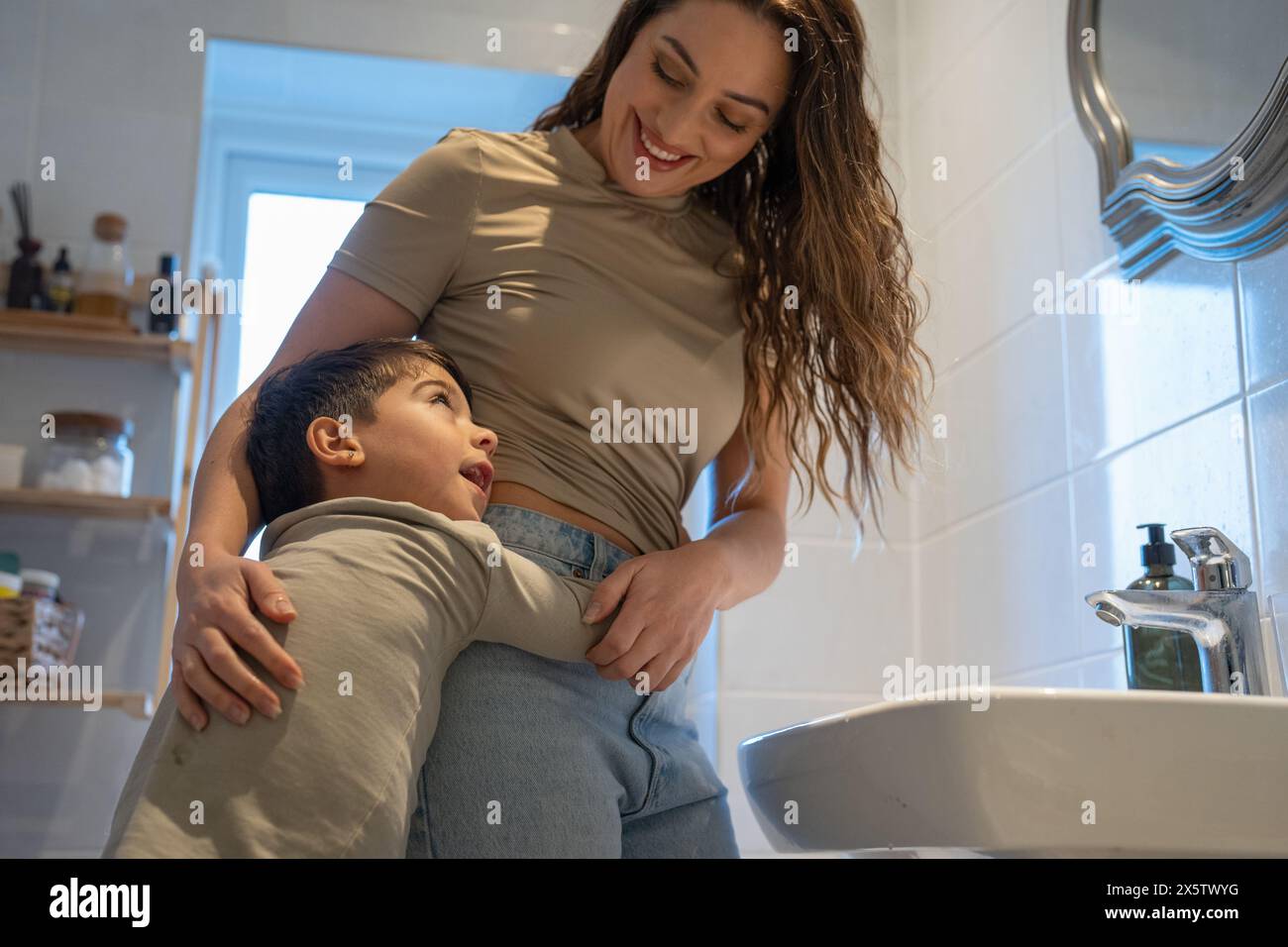 Mutter und Sohn (6-7) umarmten sich im Badezimmer Stockfoto