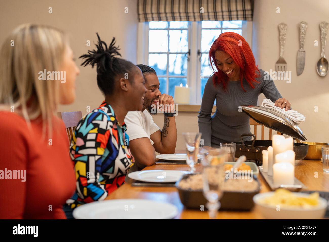 Freunde schauen sich frische Speisen auf dem Tisch an Stockfoto
