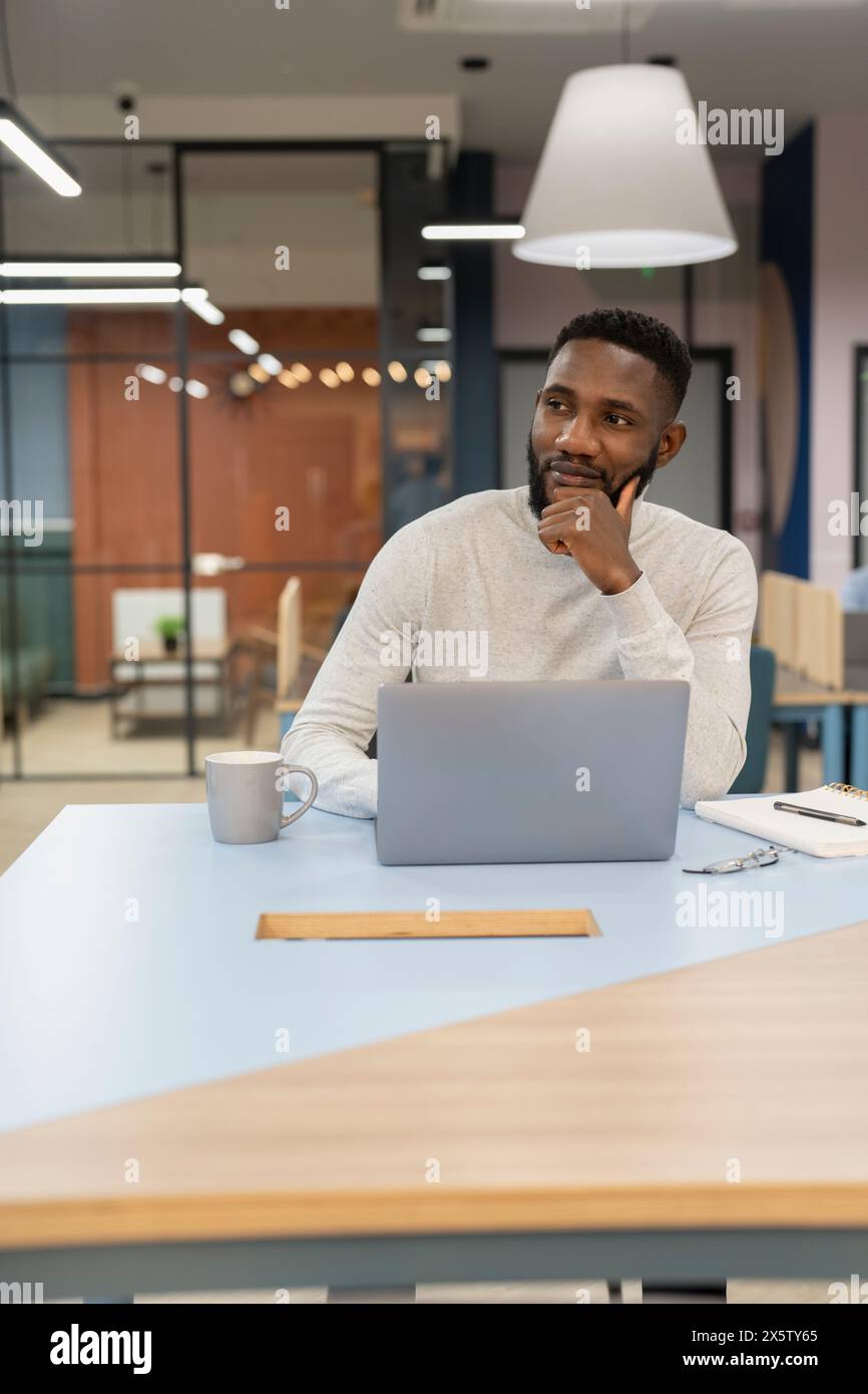 Junger Mann am Laptop im Büro arbeiten Stockfoto