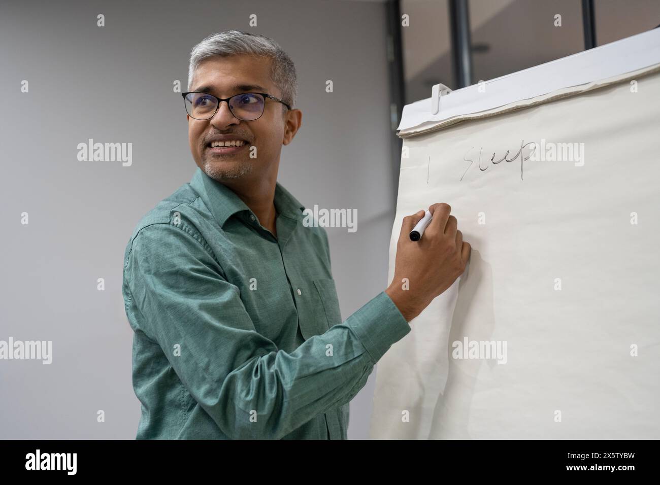 Geschäftsmann schreibt Ideen auf Flipchart Stockfoto