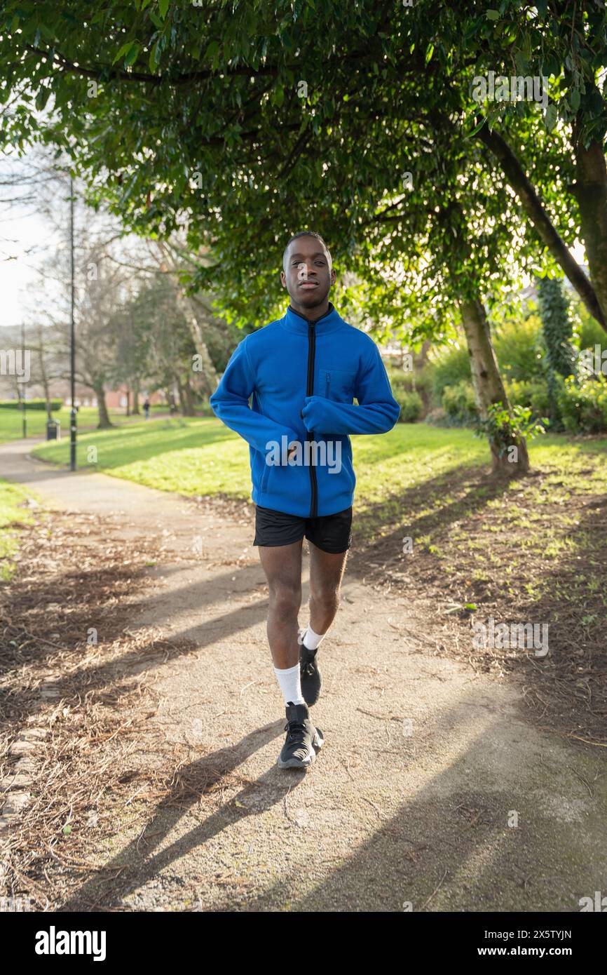 Mann, der auf dem Fußweg im Park joggt Stockfoto