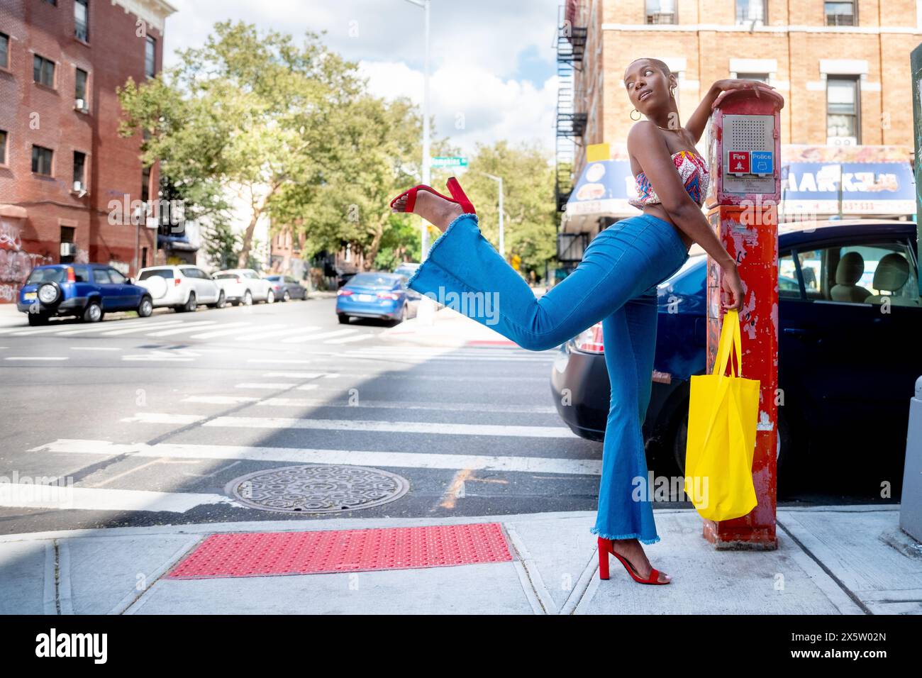 USA, New York City, schicke Frau, die auf einem Bein an der alten Parkuhr steht Stockfoto