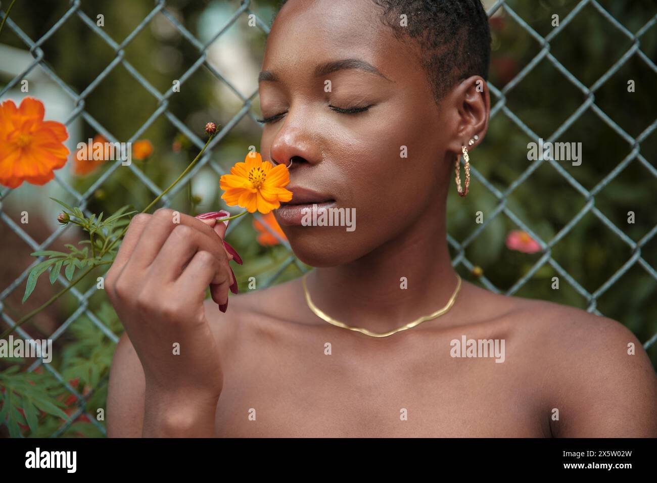 Nahaufnahme einer Frau, die Orangenblüte riecht, mit geschlossenen Augen Stockfoto