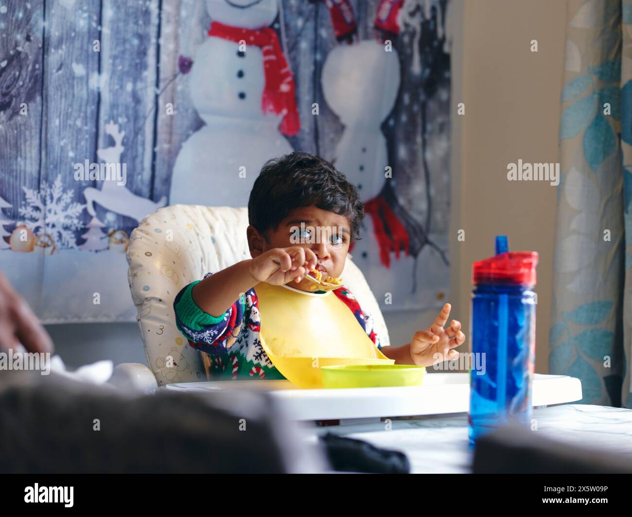 Junge isst im Hochstuhl Stockfoto