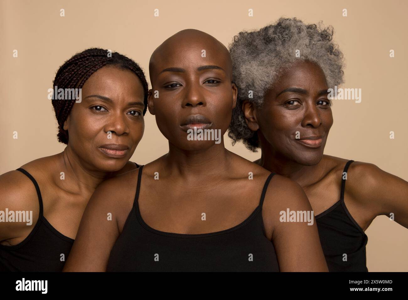 Studio-Porträt von drei selbstbewussten Frauen in schwarzen Oberteilen Stockfoto