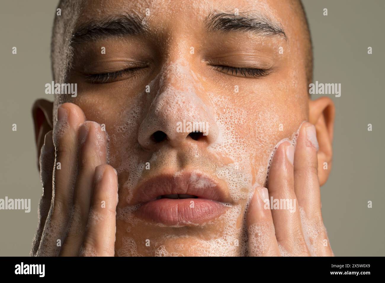Nahaufnahme des Mannes, der das Gesicht wascht Stockfoto