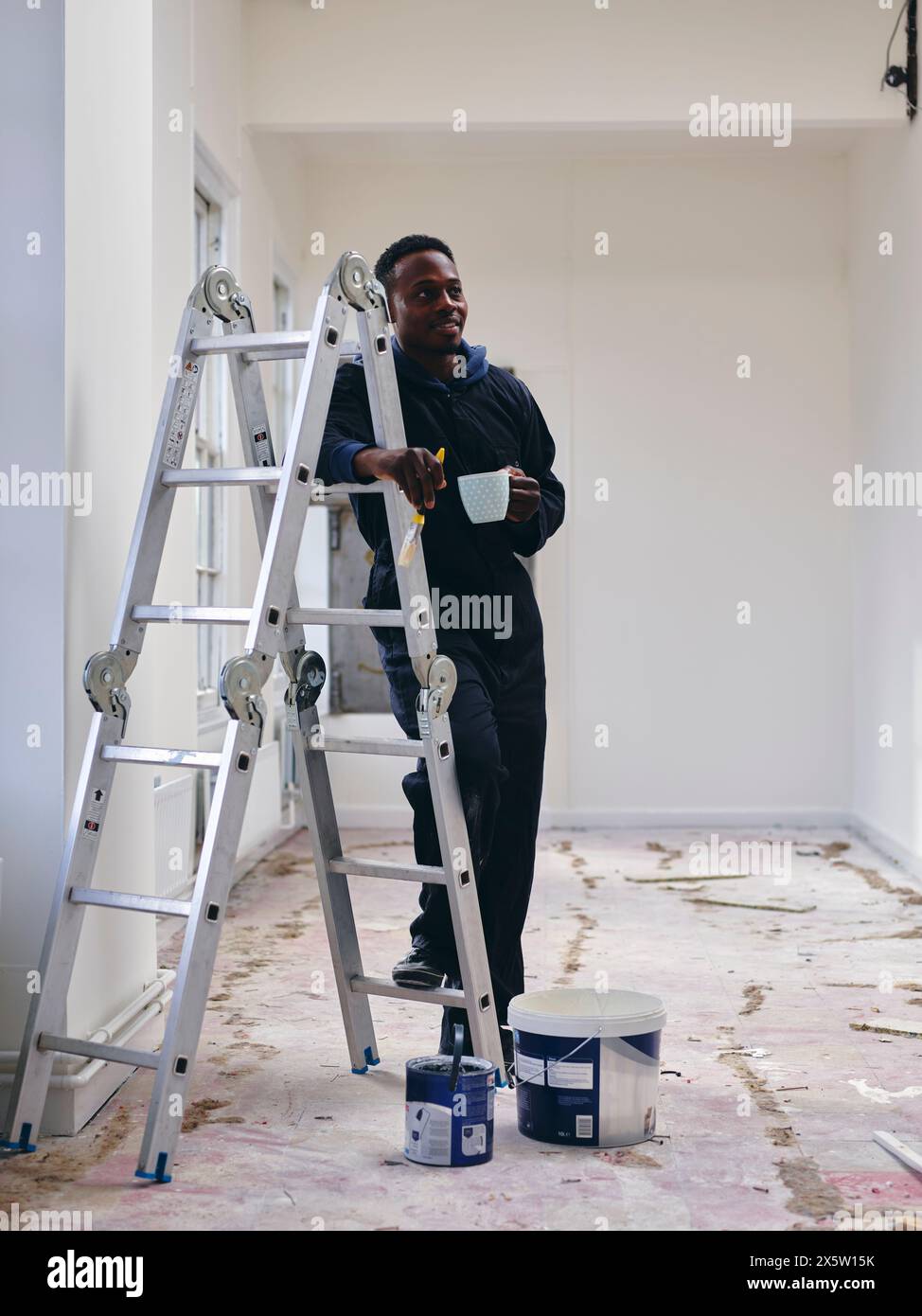 Mann mit Leiter in Loft-Wohnung Stockfoto