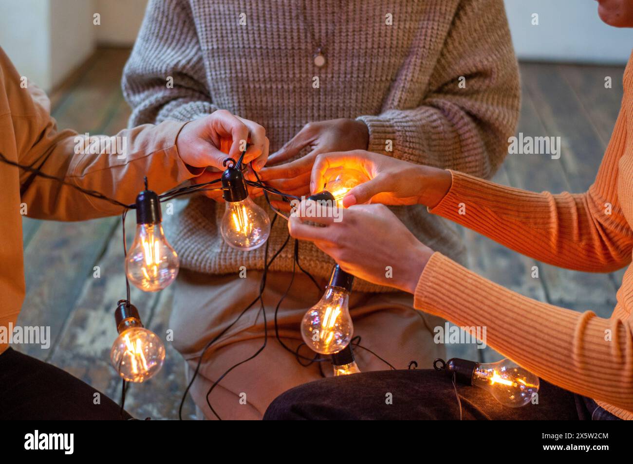 Freunde, die Lichterketten lösen, Nahaufnahme Stockfoto