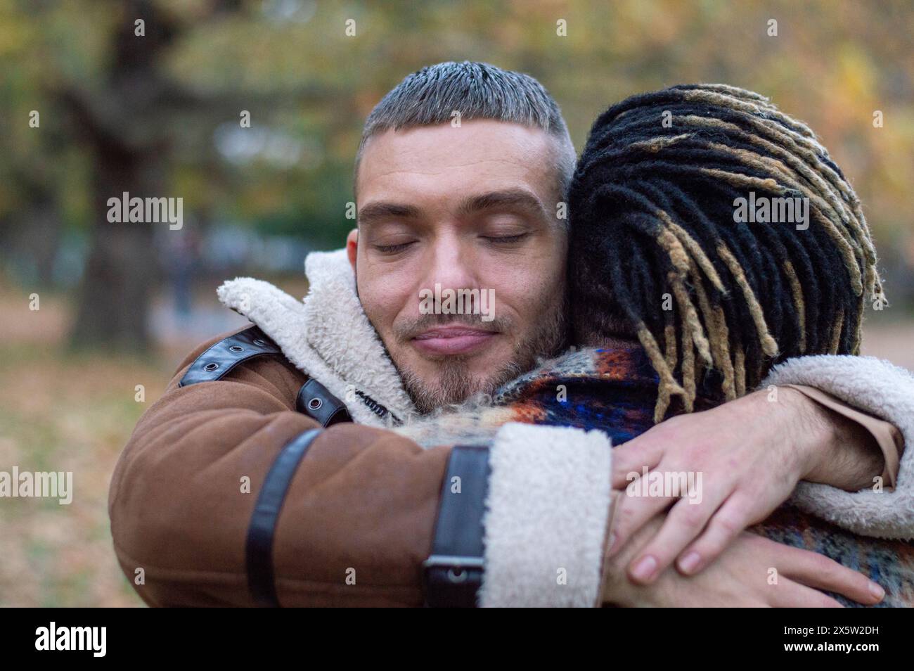 Mittelerwachsene Männer, die sich umarmen Stockfoto
