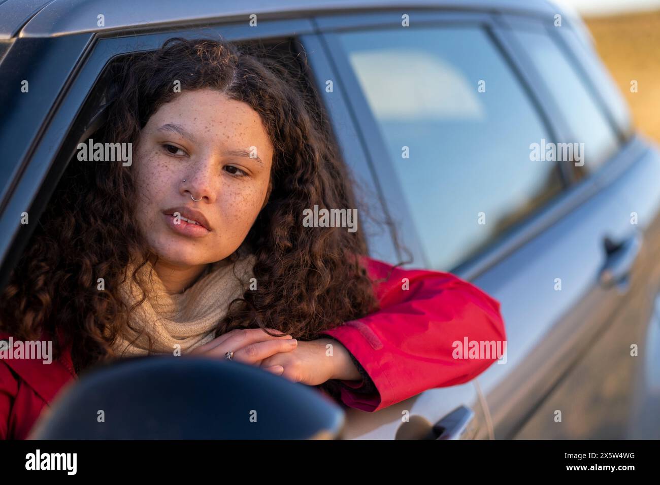 Junge Frau aus dem Autofenster Stockfoto