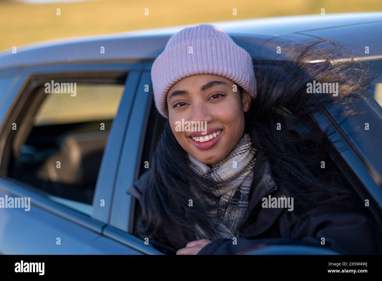 Junge Frau aus dem Autofenster Stockfoto