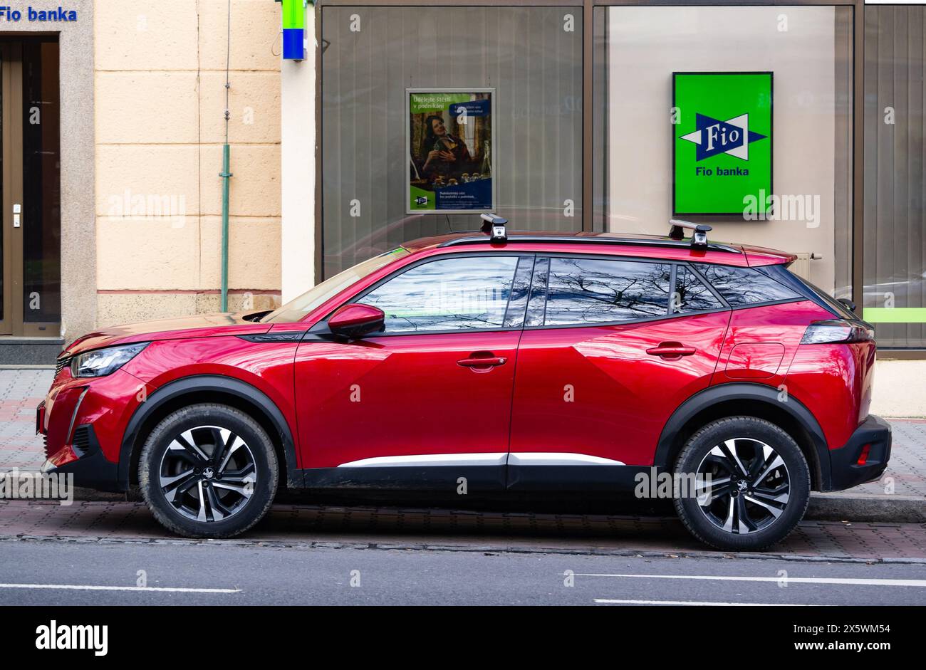 OSTRAVA, TSCHECHISCHE REPUBLIK - 19. DEZEMBER 2023: Seitenansicht des hellroten Peugeot 2008 SUV (P24), das auf der Straße geparkt ist Stockfoto