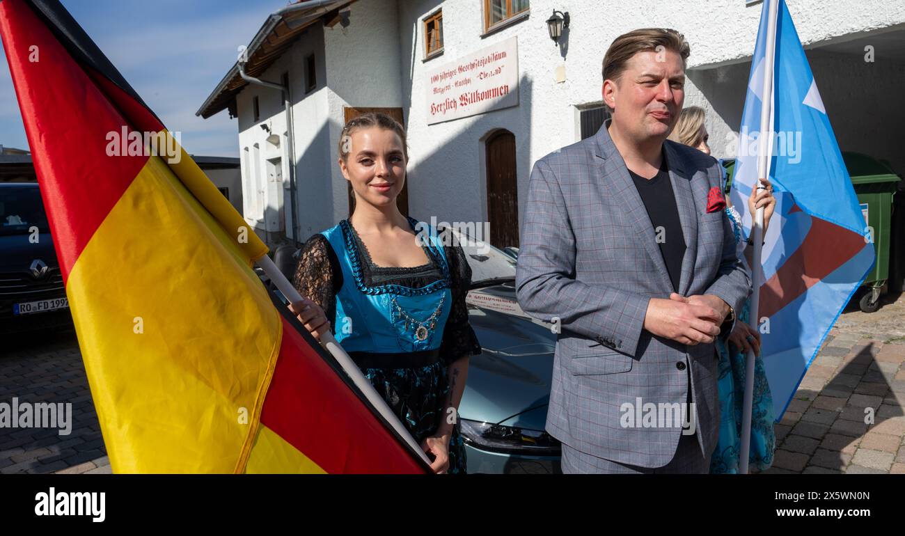 Holzkirchen, Deutschland. Mai 2024. Maximilian Krah, der Spitzenkandidat der AfD für die Europawahlen, steht während seines Wahlkampfauftritts zwischen zwei jungen Frauen mit deutscher Flagge und AfD-Flagge. Die Veranstaltung wurde aufgrund von Protesten nach Holzkirchen verlegt. Quelle: Stefan Puchner/dpa/Alamy Live News Stockfoto