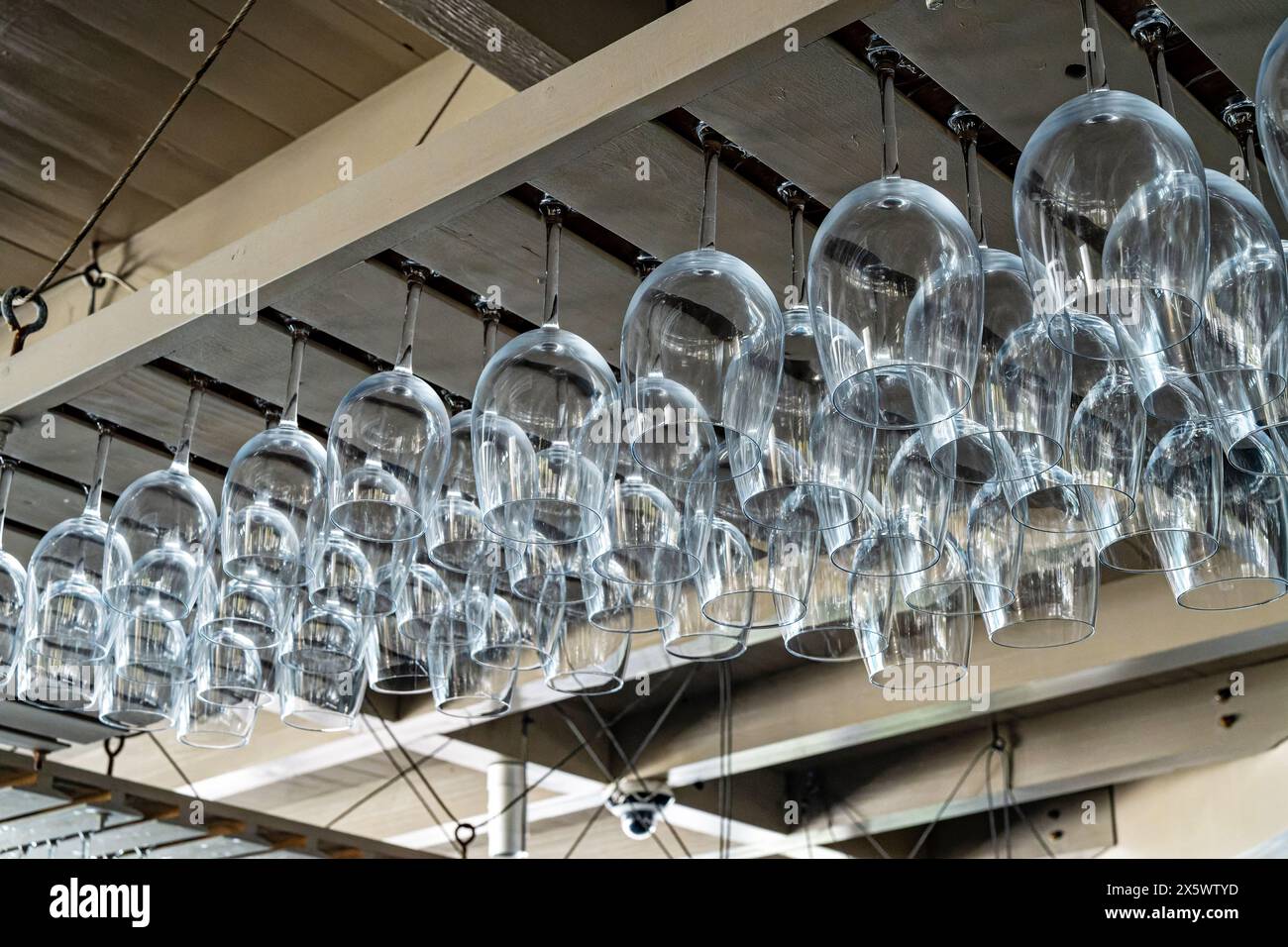 Reihen sauberer, leerer Weingläser über einer Restaurantbar in Seaside Florida, USA. Stockfoto