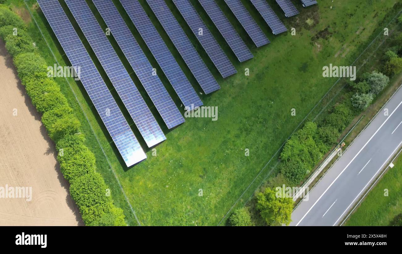 Drohnenflug auf einer deutschen Autobahn mit viel Verkehr und großen Solarpaneelen neben der Straße Stockfoto