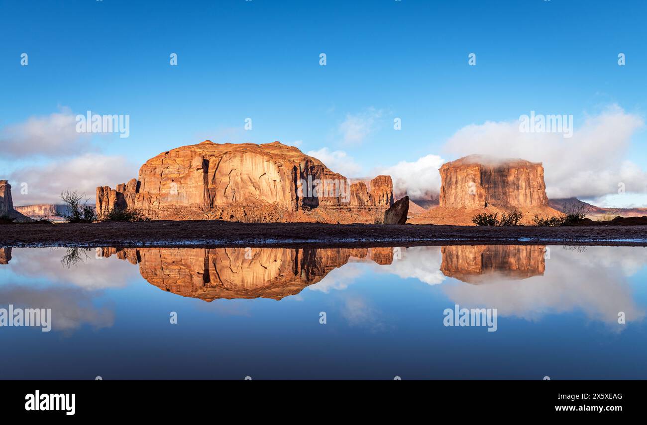 Reflexion der Berge des Monument Valley nach einer schweren Regennacht, die sich zu einem wunderschönen, lebhaften Tag entwickelt hat. Stockfoto