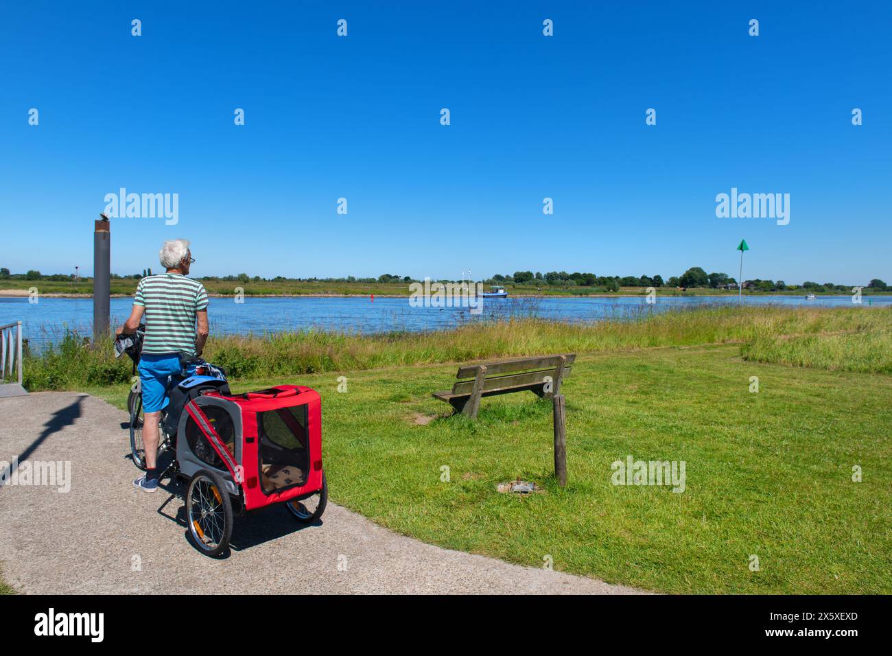 Senior Mann wartet mit seinem Hund auf die Fahrradfähre in der Nähe des Dutch River Stockfoto