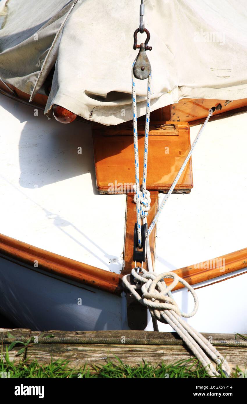 Der Bug eines Segelbootes mit Details, die an den Liegeplätzen im Pleasure Boat Dyke auf den Norfolk Broads in Hickling, Norfolk, England, Vereinigtes Königreich befestigt sind. Stockfoto