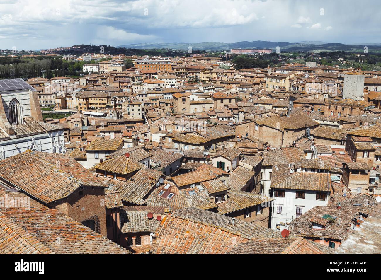 Die Dächer der historischen mittelalterlichen Stadt Siena in der Toskana, Italien an einem sonnigen Tag mit blauem Himmel und Wolken. Vom Panorama dal Facciatone aus gesehen. Stockfoto