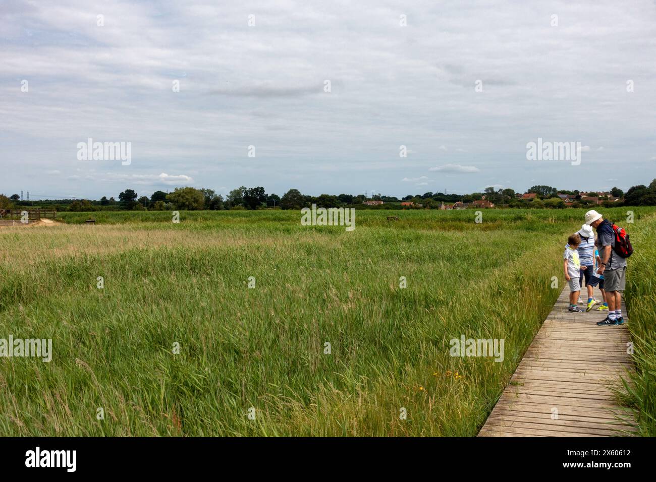 Besucher, die Namen sehen, die in eine hölzerne Promenade geschnitzt wurden, Snape Maltings Suffolk UK Stockfoto
