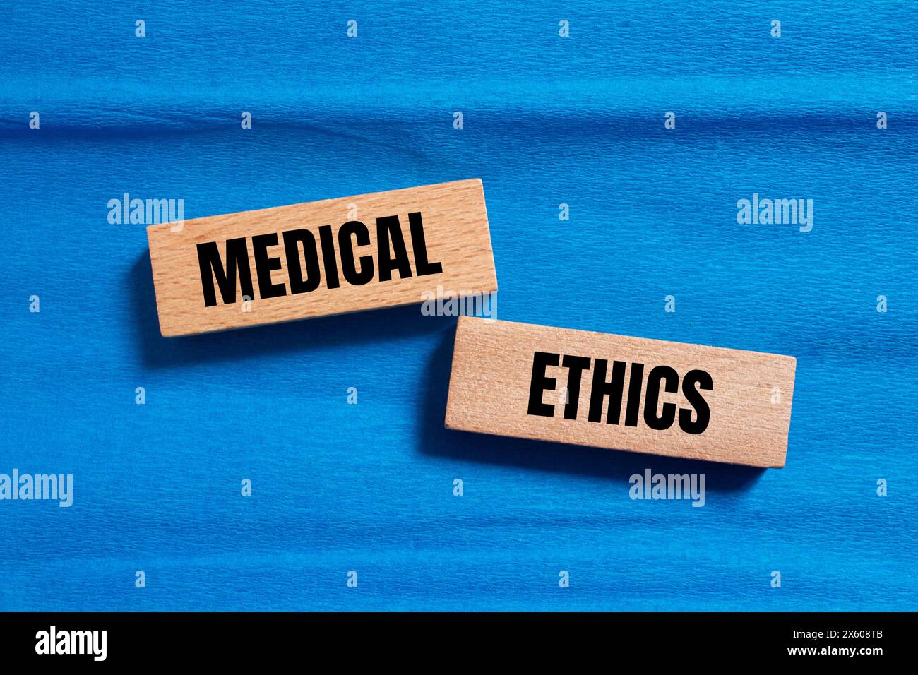 Medizinische Ethik Wörter auf Holzblöcken mit blauem Hintergrund geschrieben. Konzeptuelles medizinisches Ethiksymbol. Kopierbereich. Stockfoto