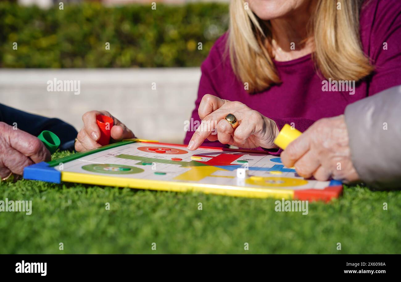 Nahaufnahme einer Familie, die ein Brettspiel spielt. Psychische Gesundheit im Alter Stockfoto
