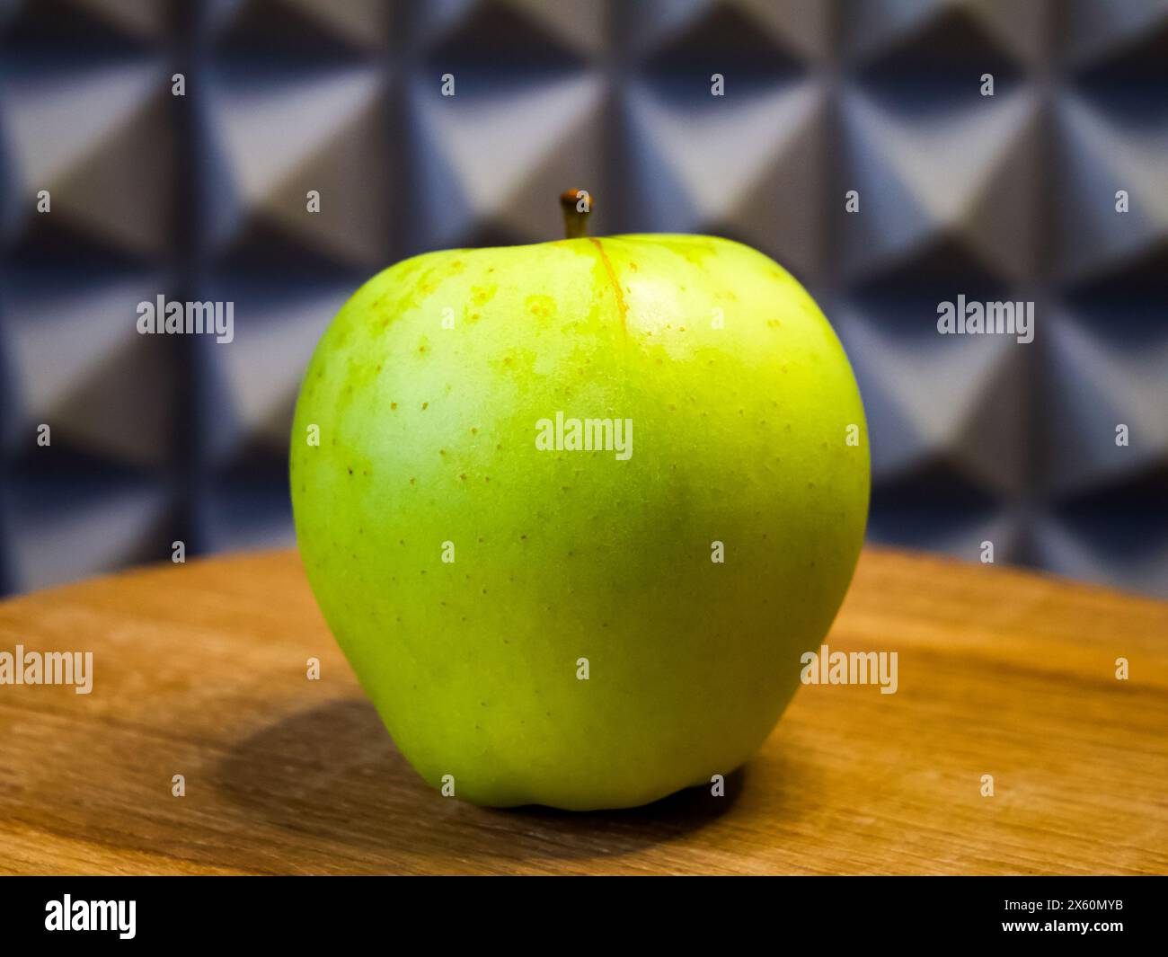 Frischer grüner Apfel auf Holz, symbolisiert Gesundheit und Einfachheit, ideal für Wellness-Kampagnen. Stockfoto