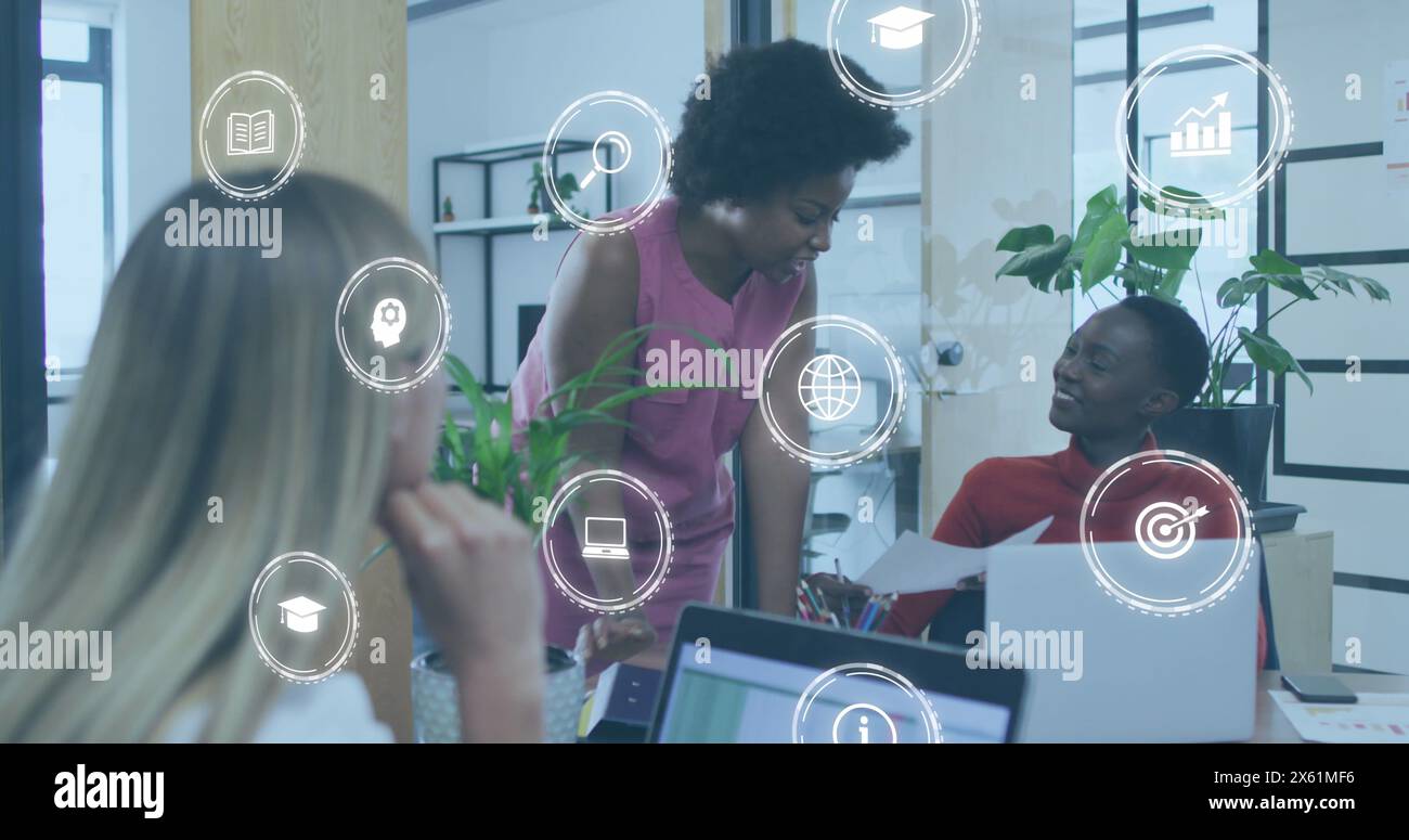 Bild eines Symbols in Kreisen über weiblichen Kollegen, die Berichte im Büro diskutieren Stockfoto