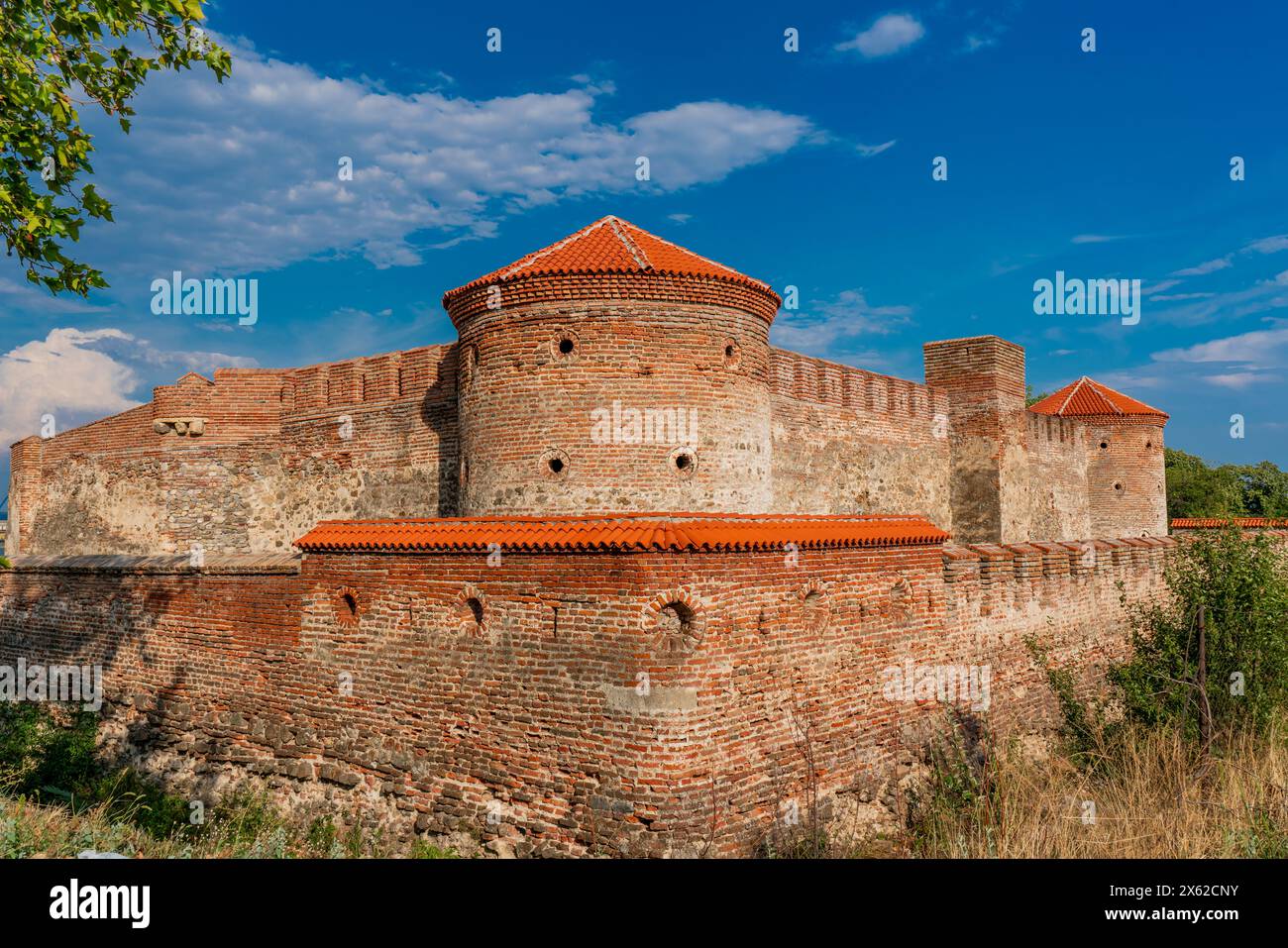 Alte Mauern und das rot gekachelte Dach der Fetislam Festung stehen stolz vor einem lebhaften Sommerhimmel. Stockfoto