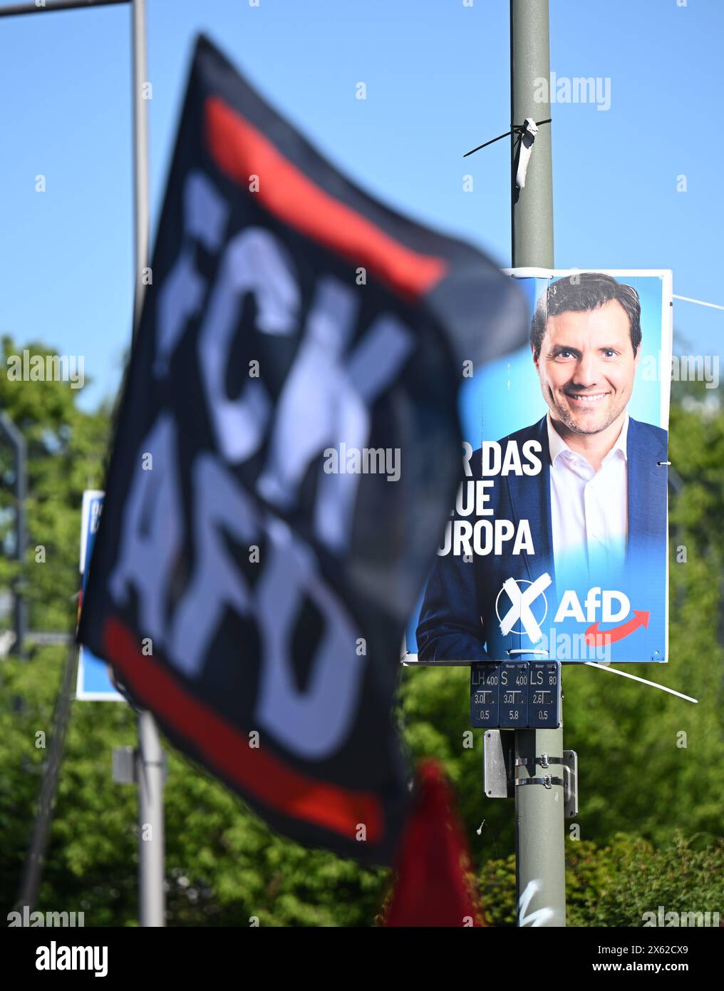 Berlin, Deutschland. Mai 2024. Eine Flagge mit der Aufschrift „FCK AFD“ fliegt während einer Demonstration unter dem Motto „alle zusammen gegen Faschismus! Kein Platz für die AfD!“ Von linken Gruppen gegen die neue AfD-Bundeszentrale vor einem AfD-Wahlplakat für die Europawahlen. Quelle: Sebastian Christoph Gollnow/dpa/Alamy Live News Stockfoto