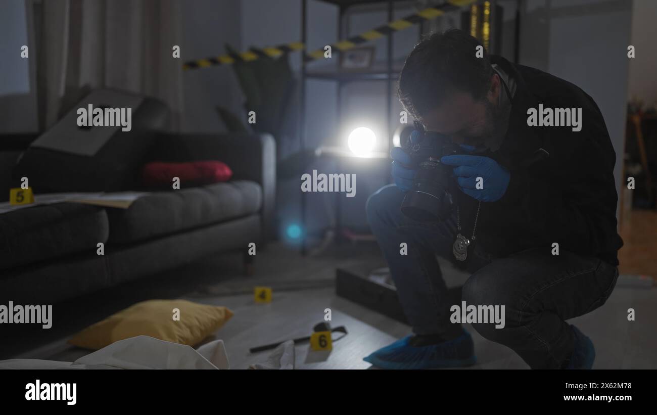 Ein Detektiv mittleren Alters fotografiert Beweise am Tatort in Innenräumen mit Kamera und Taschenlampe. Stockfoto