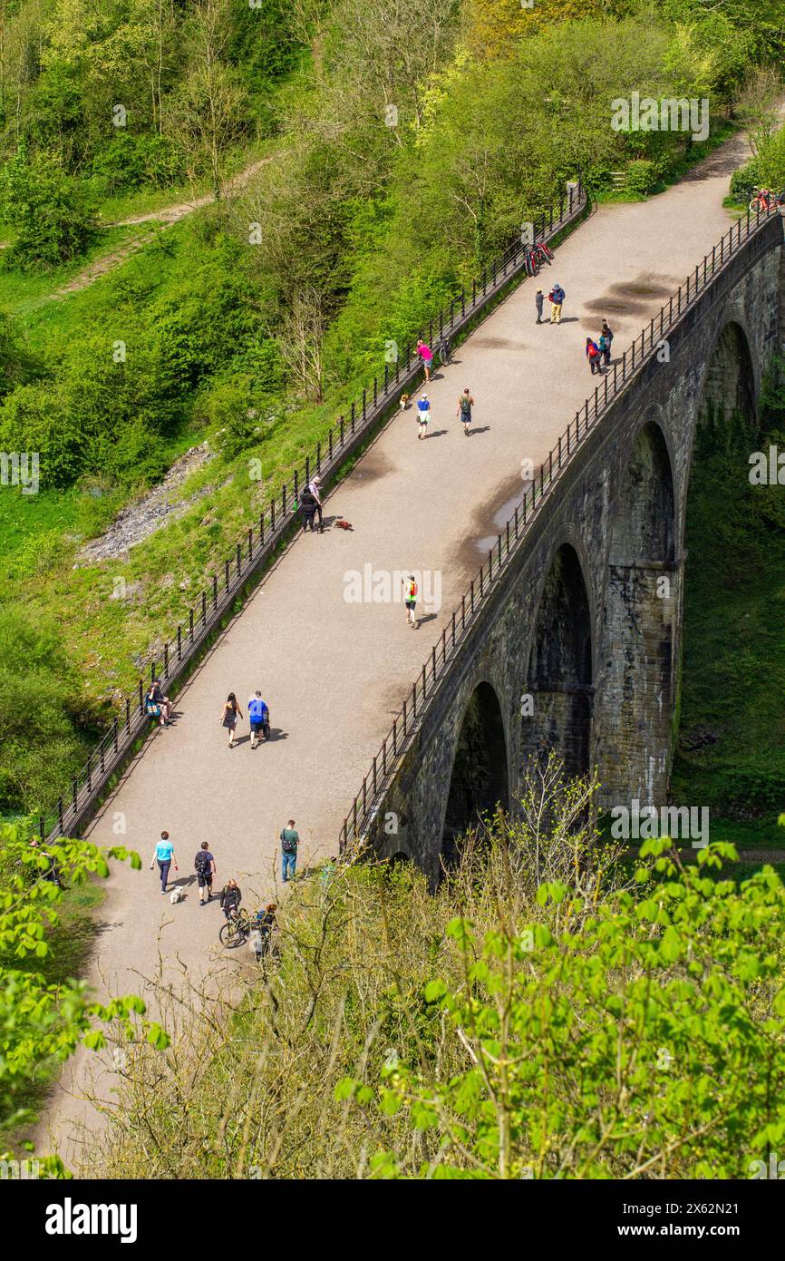 Menschen, die die Frühlingssonne genießen, wandern und radeln auf dem Monsal Trail über das Grabsteinviadukt am Monsal Head, wo er den Fluss Wye überquert Stockfoto