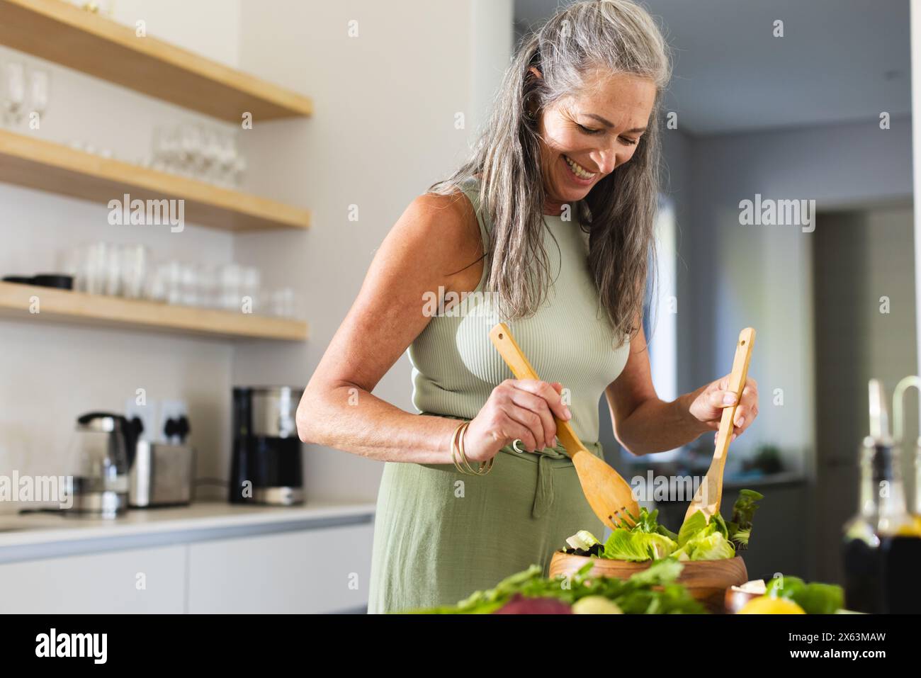 Zu Hause, reife weiße, die Salat zubereitet, ärmelloses Kleid trägt Stockfoto