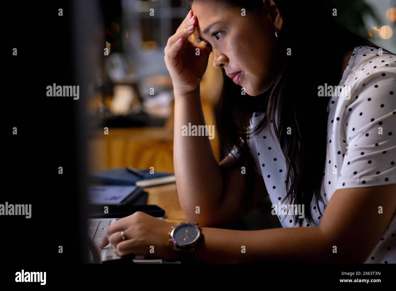 Im Büro untersucht birassische Geschäftsfrau Geschäftsdaten Grafiken, arbeitet spät Stockfoto