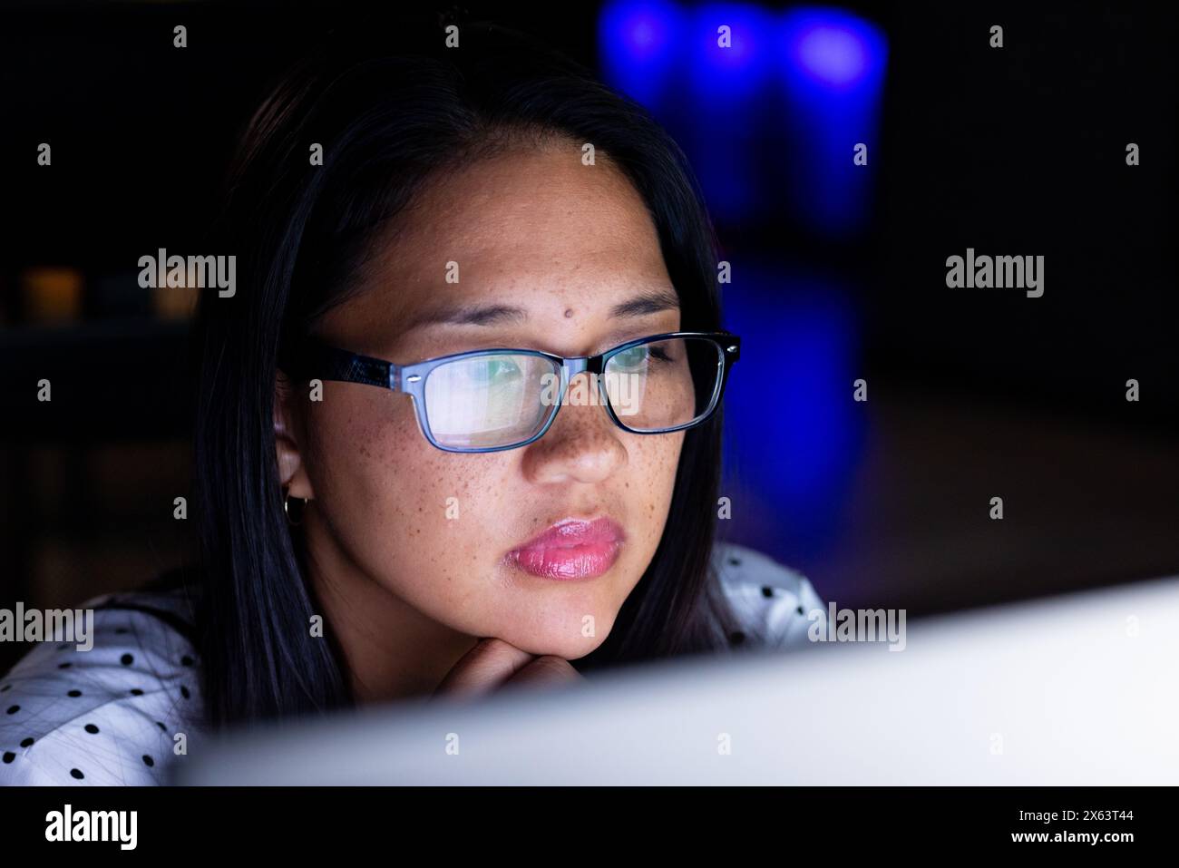 Birassische Geschäftsfrau mit Brille arbeitet spät und konzentriert sich im Büro auf den Computerbildschirm Stockfoto