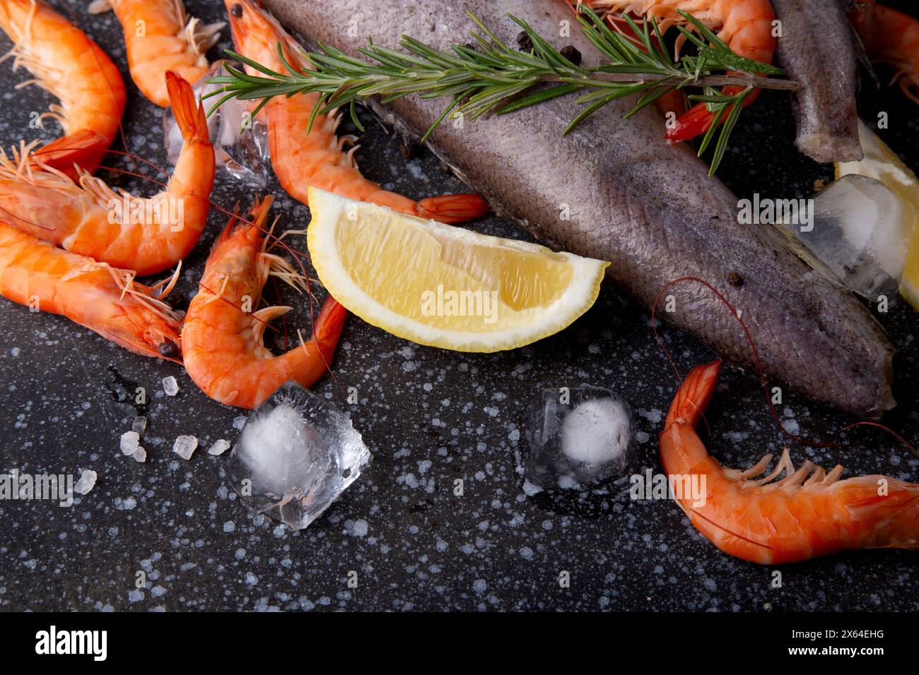 Auswahl an natürlichen und frischen Meeresfrüchten auf Stein. Shrimps und Seehecht. Stockfoto